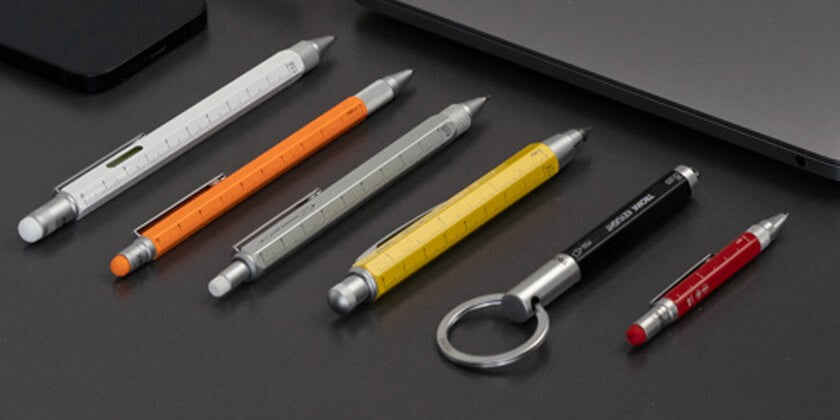 different pens and pencils in front of laptop