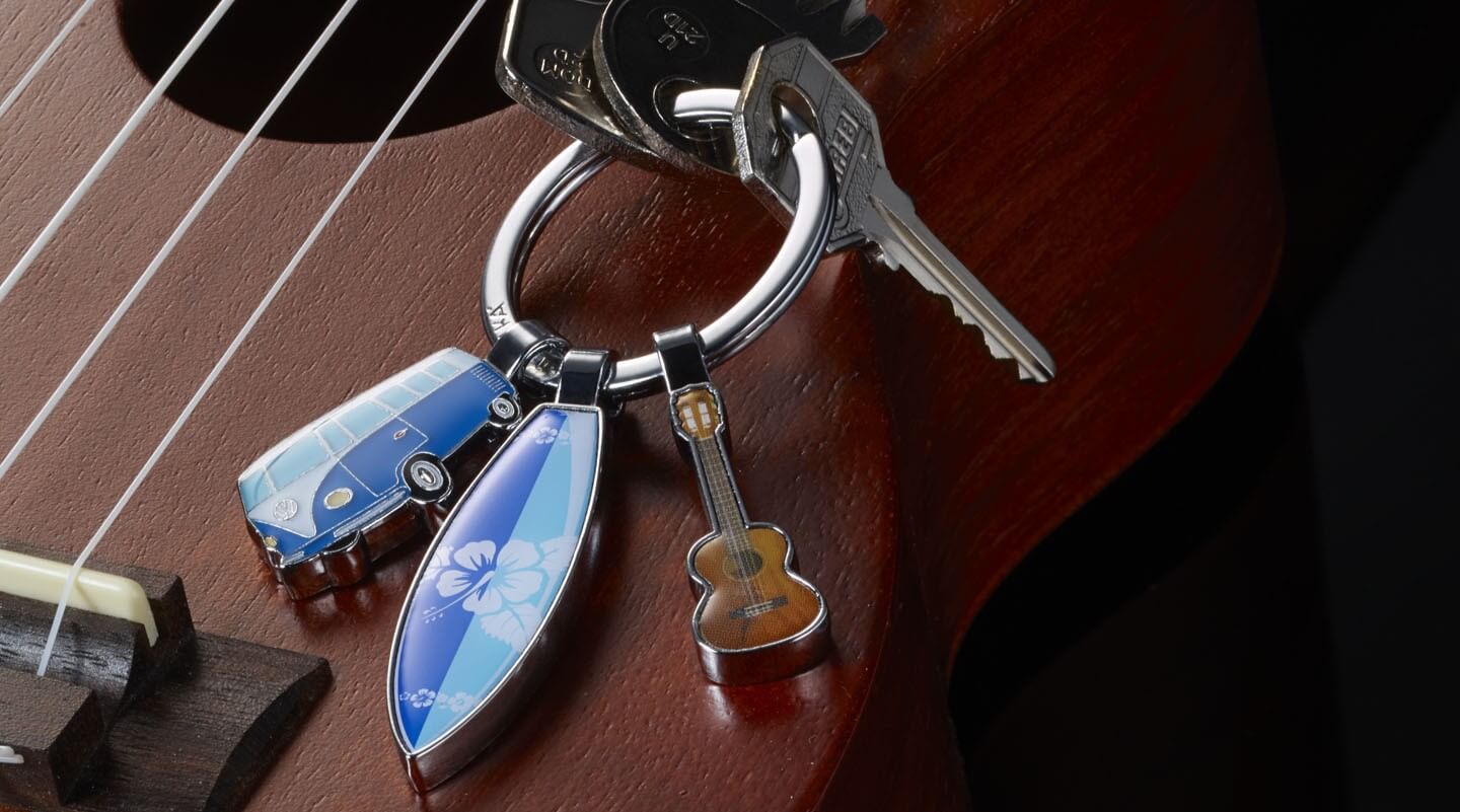 Troika Keychain with 3 charms and a guitar in the background