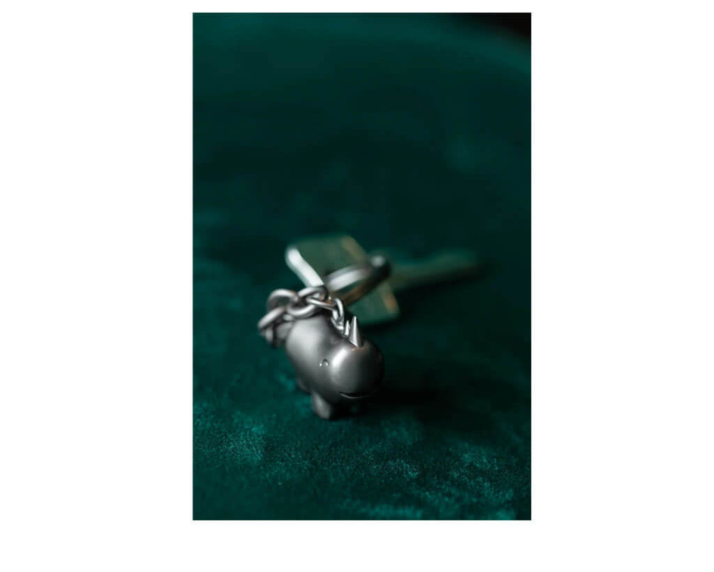 TROIKA HAPPY RHINO keyring featuring a cute rhinoceros design in matt gunmetal chrome-plated metal. A cheerful accessory and gift with personality.